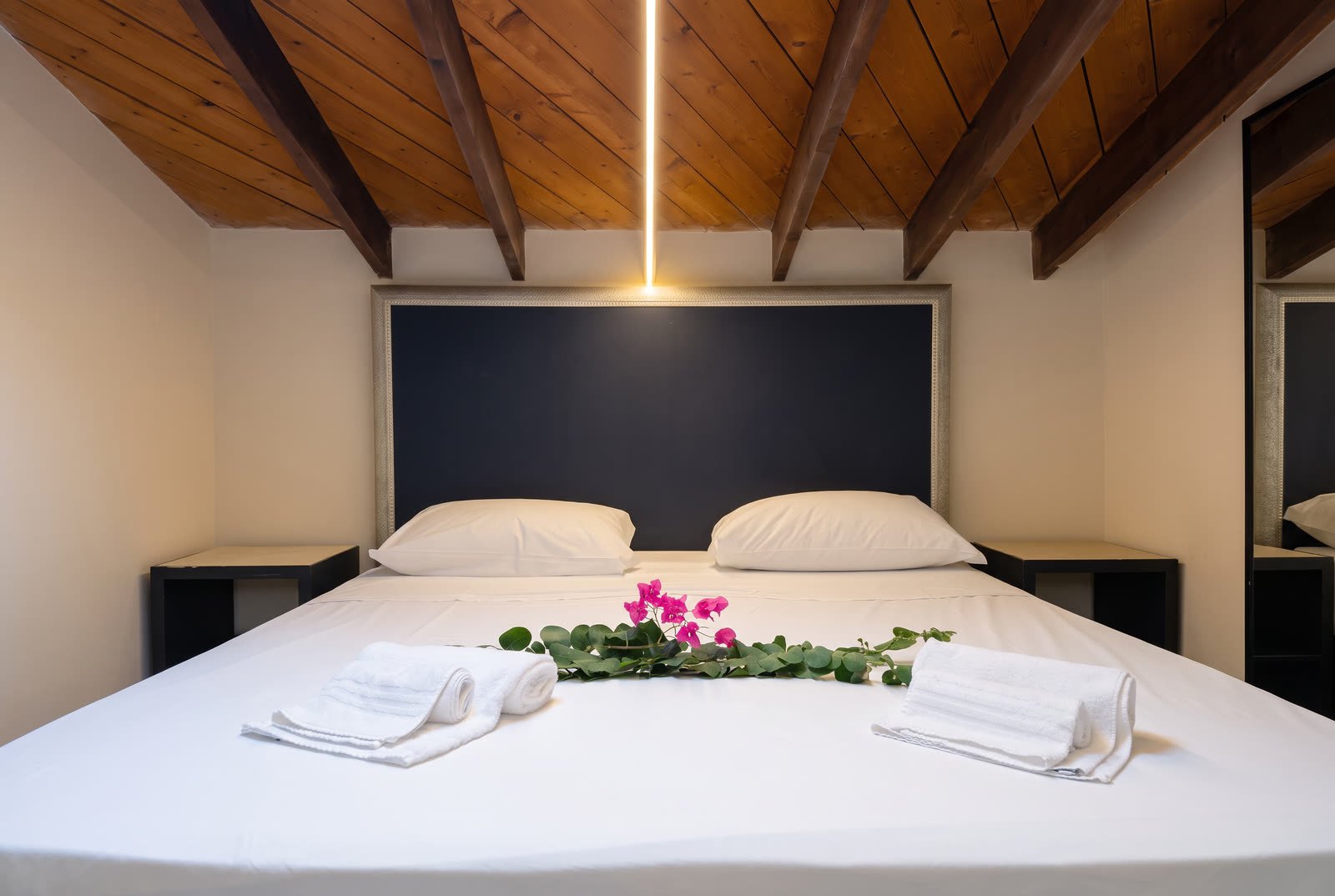 Al Castello — letto matrimoniale sotto il tetto in travi di legno